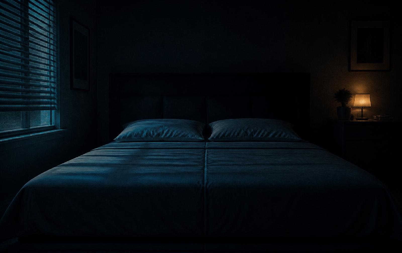 An empty, neatly made bed in a dim bedroom: the quiet distance the Unilateral Reset is designed to close